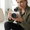 Person using a 4K UHD Digital Camera for photography in a well-lit studio setting.