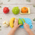 Children playing with the Playful Produce Cutting Set, cutting colorful toy fruits and vegetables on a cutting board.