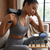 Woman using a Professional Deep Tissue Muscle Massage Gun on her neck with attachments displayed.