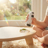 Child using Mini Portable Microscope to examine a leaf on a wooden table in a sunlit room.