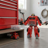 2-in-1 Take-Apart Fire Truck Robot Toy standing beside a toolbox in a garage setting.