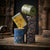 Kiddies Money Bank Tin with Coin Slot stacked in colorful designs on a rustic table with coins.