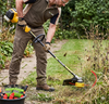 Person using Heavy-Duty Trimmer Line 10m for garden maintenance and weed clearing.
