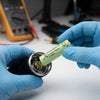 Person installing an AA Rechargeable Ni-MH Battery 1.2V 400mAh into a device with blue gloves on.