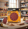 5-Inch 8-Hole Aluminum Oxide Sanding Discs package displayed in a workshop with tools and sanding machines.