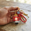 A hand holding a Pixel Character Light-Up Keychain attached to keys, featuring a playful pixel-style character design.
