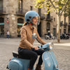 Woman riding a scooter wearing an Open-Face Helmet with Clear Visor in a city setting.