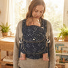 A caregiver using an Adjustable Baby Carrier with a baby comforted in a cozy home setting.