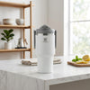 1200ml Insulated Travel Tumbler on a marble table with lemon and leaves in the background.