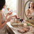 Woman organizing cosmetics using the Multi-Compartment Desktop Storage & Organiser Tray on a vanity.