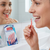 A woman using Dentiplus Interdental Brushes 5 Pack for oral hygiene in the bathroom.