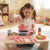 Kids Kitchen Pretend Playset with Cooking Accessories, girl playing with toy stove and cooking utensils.