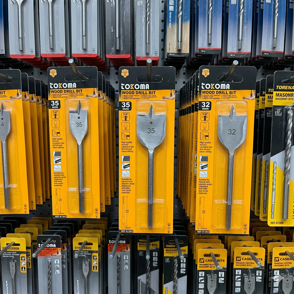 35mm Quick-Change Tri-Point Flat Wood Drill Bit and 32mm wood drill bits displayed on a store shelf.