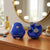 4-Head Cordless Electric Massager in blue color on wooden surface, showcasing its compact design and massage heads.