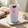 350ml Stainless Steel Travel Mug on a wooden table with a notebook and succulent plant, featuring a pink and blue gradient design.