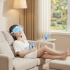 Woman relaxing on a sofa wearing a Cooling Gel Eye Mask, with a thermometer showing 18°C and a relaxing environment.
