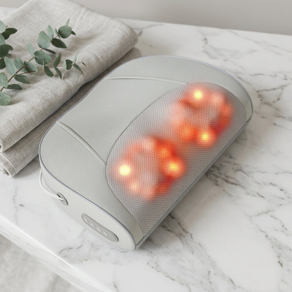 Electric Back and Neck Massage Cushion with heated massage nodes on a marble table.