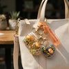 Capybara Acrylic Bag Pendant Keychain attached to a stylish handbag with decorative charms and bright colors.