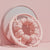 32 Wheel Ring Muscle Relaxation Leg Massager on a pink surface with a mirror backdrop.