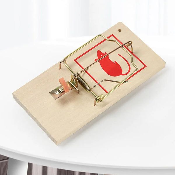 Heavy Duty Wooden Snap Mousetrap on a white table capturing effective rodent control.