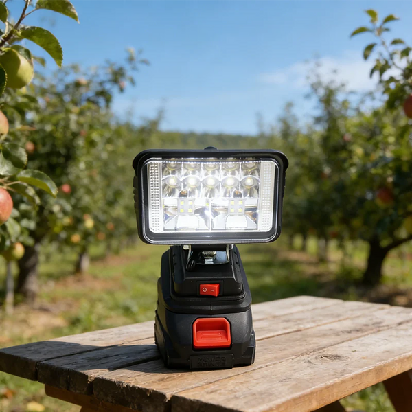 9W 1440LM Outdoor Camping Emergency Flashlight Work Light on a wooden table in an orchard.