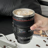 Camera Lens Travel Mug with Lid filled with iced coffee, resembling an actual camera lens.