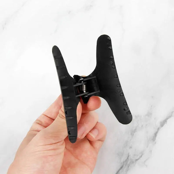 12 Piece Butterfly Hair Sectioning Clips in hand, showcasing the design and functionality for secure hair styling.