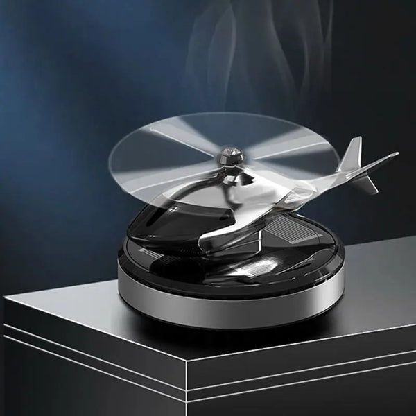 Solar-Powered Rotating Helicopter Car Air Freshener displayed on a surface with smoke and rotating propeller.