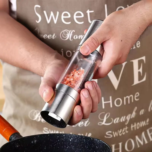 Person using a 2-in-1 Stainless Steel and Bamboo Manual Grinder to season food in a pan.
