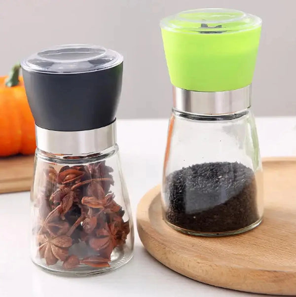 Manual Stainless Steel Pepper & Salt Grinder Mill in modern design with colorful tops, showcasing spices in glass containers.