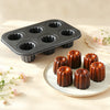 Carbon Steel 6-Cup Cannelé Baking Tray with freshly baked cannelés displayed on a plate, showcasing perfect caramelization.
