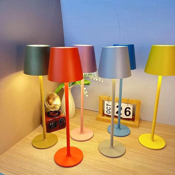 Colorful portable LED touch table lamps in various styles on a table with a clock and decorative elements.