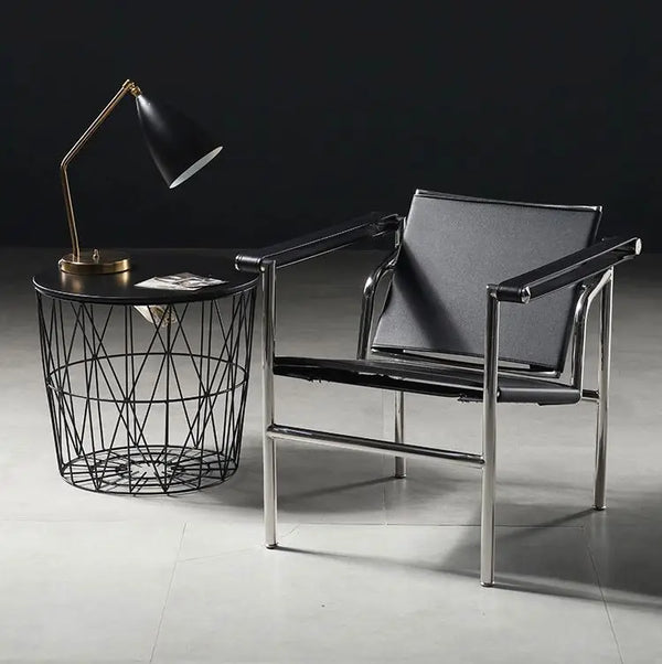 Modern MDF Veneer Dining Table: Sleek black modern chair with metallic frame beside a wire basket table and stylish lamp in a contemporary setting.