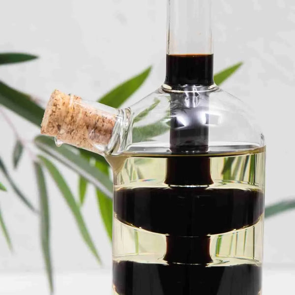 2 in 1 Olive Oil Vinegar Bottle Dispenser showing cork stopper and liquid layers, perfect for functional decor in homes.