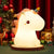Kids Gifts LED Touch Sensor Baby Night Light in the shape of a unicorn, glowing softly beside festive decorations.