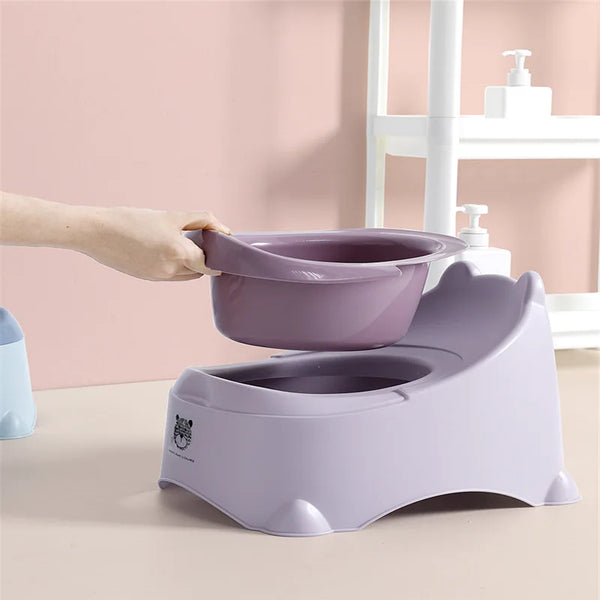 Person holding the removable bowl of the New Plastic Baby Training Potty in a light purple color.