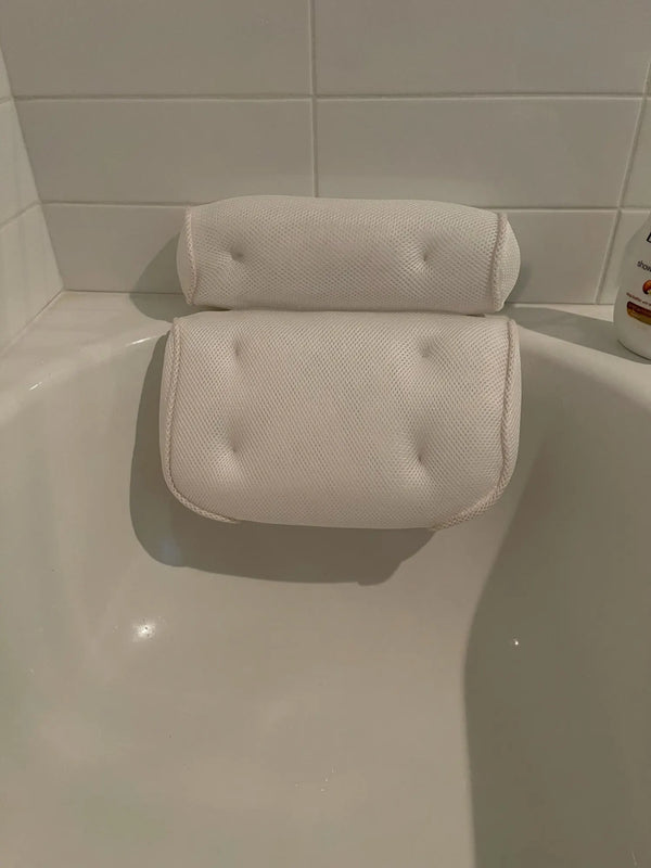Non Slip Take Bath Pillow with Suction Cups resting on the edge of a bathtub.