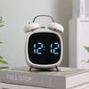 Digital Loud Bell Alarm Clock with Snooze displaying time 12:12 on a bedside table.