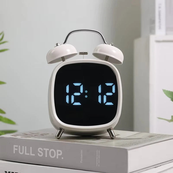 Digital Loud Bell Alarm Clock with Snooze displaying time 12:12 on a bedside table.