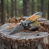 3D Pattern Blade Olive Wood Handle Pocket Knife resting on a wooden log in a forest setting.