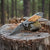 3D Pattern Blade Olive Wood Handle Pocket Knife resting on a wooden log in a forest setting.