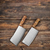 Heavy Duty Stainless Steel Bone Chopping Butcher Cleaver positioned on a wooden surface, showcasing its robust design and sharp blades.