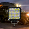 Waterproof Off-Road LED Work Light illuminating outdoor area at night with vehicle in background.