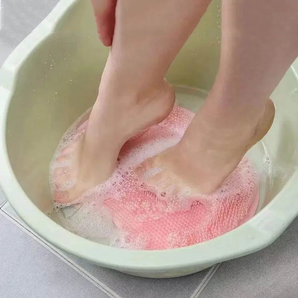 Person using Soft Body Massage Bath Brush to exfoliate feet in a water bath.