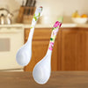 Two Ceramic Flower Handle Soup Spoons on a kitchen table, showcasing floral designs and smooth white bowls.