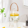 Glass Beverage Dispenser with Faucet showcasing lemon slices, stylish and functional for serving cold drinks.