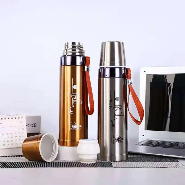 600ml Stainless Steel Thermos Bottle in gold and silver color next to a laptop and calendar.