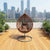 Modern Indoor-Outdoor Swing Chair featuring a stylish suspended design with cozy cushions, set against a city skyline.