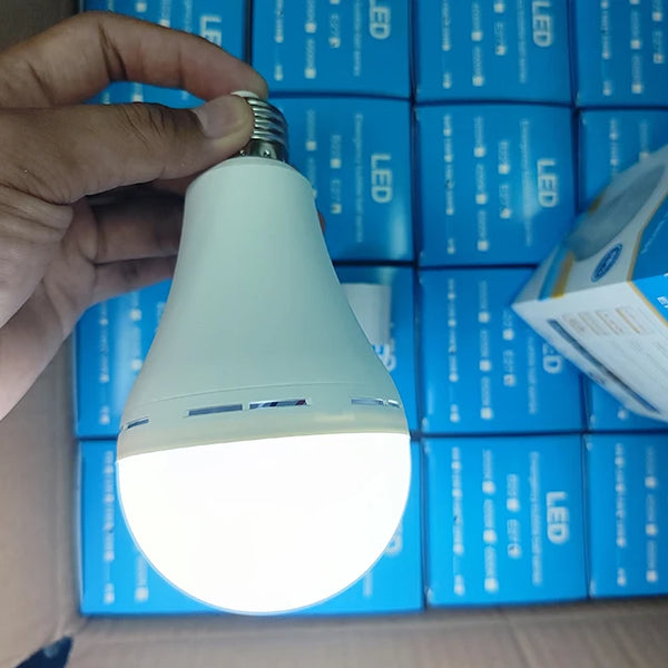 20W Rechargeable Emergency LED Bulb being held, showcasing its bright light and design among blue LED bulb packaging.