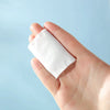 3 Layers Square Cotton Pads held in a hand, showcasing their compact size for effective facial care.